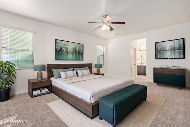 carpeted bedroom featuring ceiling fan and connected bathroom