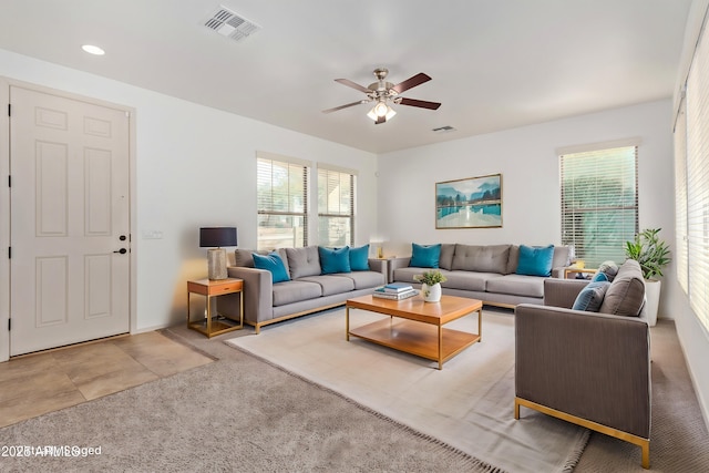 living room with ceiling fan, carpet flooring, and a healthy amount of sunlight