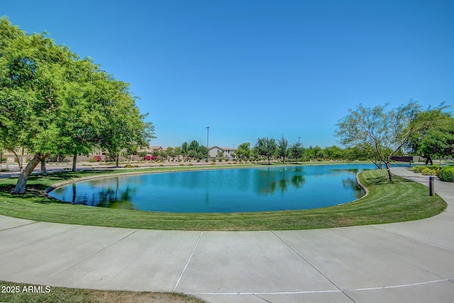 view of swimming pool featuring a water view and a lawn