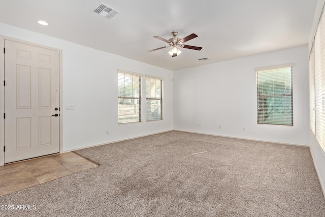 carpeted spare room featuring ceiling fan