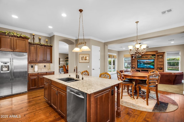 kitchen featuring visible vents, open floor plan, dark wood-style floors, stainless steel appliances, and a sink