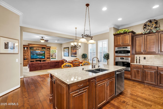 kitchen with dark wood-style floors, a healthy amount of sunlight, tasteful backsplash, and a sink