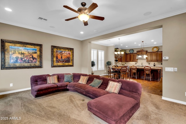 carpeted living area featuring visible vents, ceiling fan with notable chandelier, crown molding, and baseboards