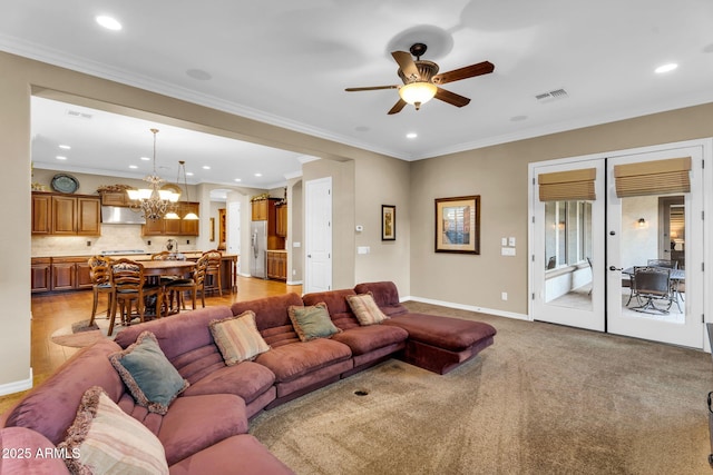 living room featuring visible vents, baseboards, recessed lighting, crown molding, and ceiling fan with notable chandelier