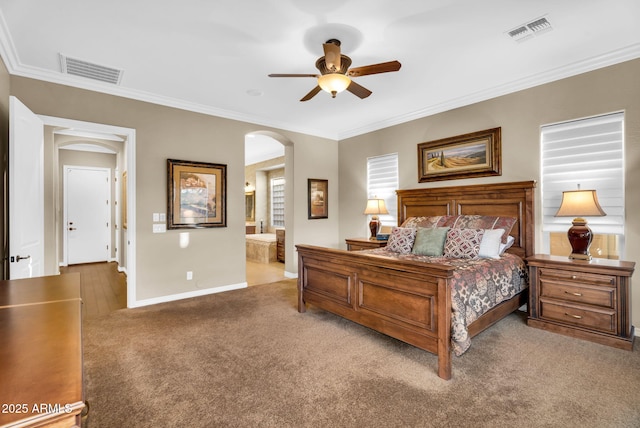 bedroom featuring arched walkways, visible vents, crown molding, and carpet