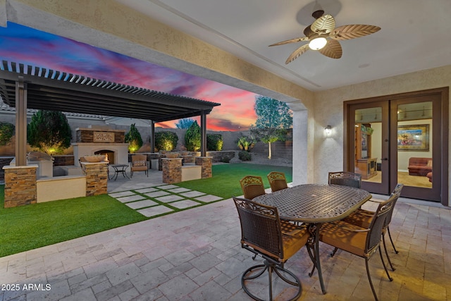 view of patio with area for grilling, outdoor dining space, a pergola, a lit fireplace, and ceiling fan