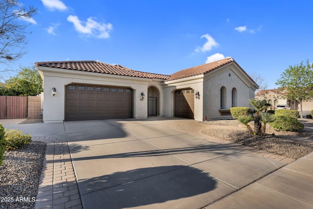 mediterranean / spanish-style house featuring a tiled roof, a garage, driveway, and stucco siding