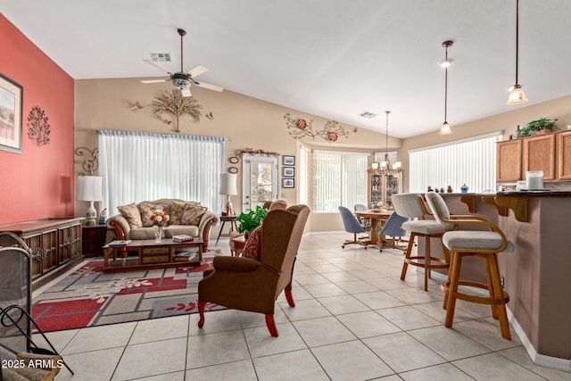 tiled living room with vaulted ceiling and ceiling fan with notable chandelier