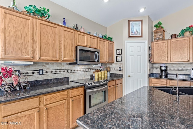 kitchen with stainless steel appliances, decorative backsplash, dark stone countertops, vaulted ceiling, and sink