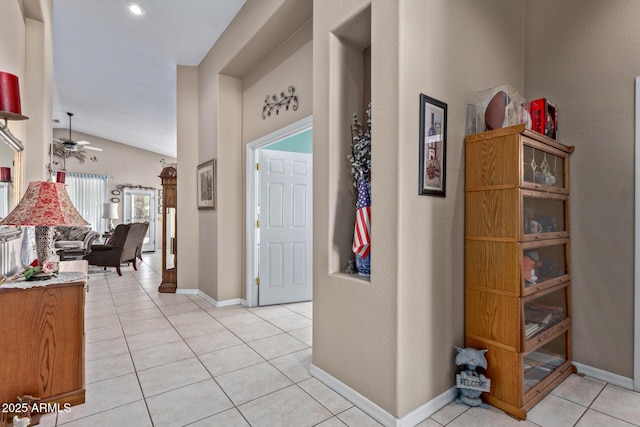 foyer featuring ceiling fan, light tile patterned flooring, and lofted ceiling