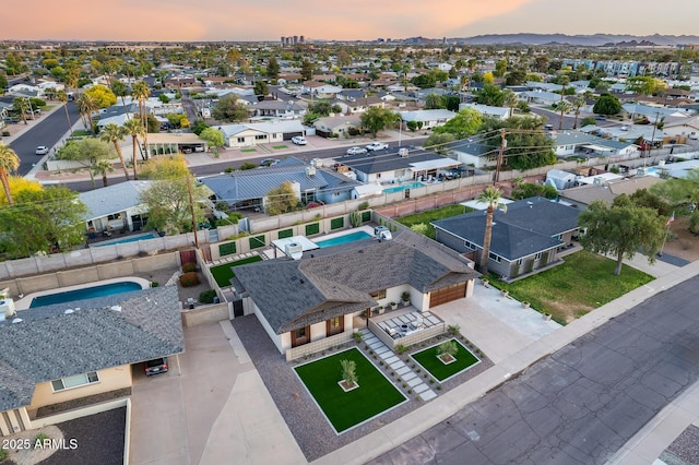 aerial view at dusk featuring a mountain view and a residential view