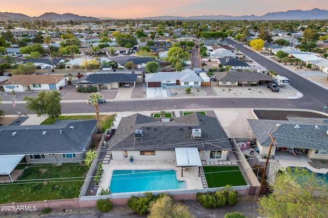 aerial view at dusk featuring a residential view and a mountain view
