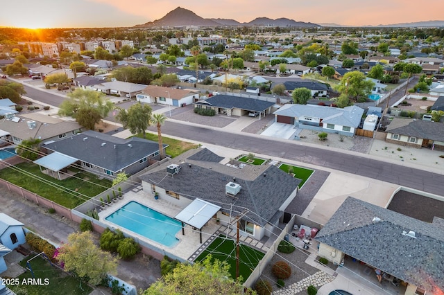 aerial view at dusk featuring a residential view and a mountain view