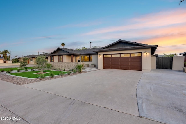 single story home featuring an attached garage, driveway, stucco siding, and a front yard