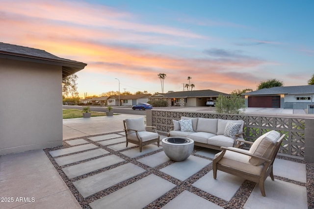patio terrace at dusk featuring an outdoor living space