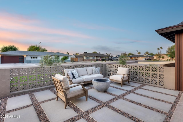 patio terrace at dusk featuring outdoor lounge area and a residential view