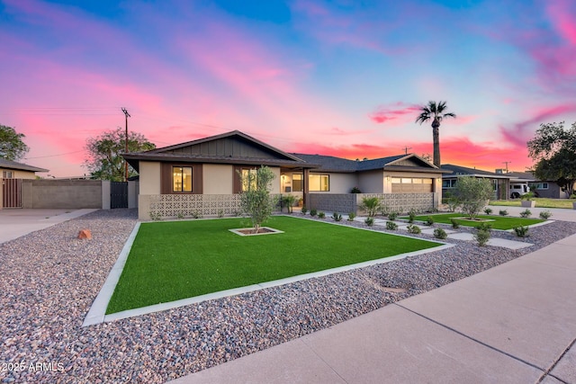 view of front of property with stucco siding, fence, and a front lawn