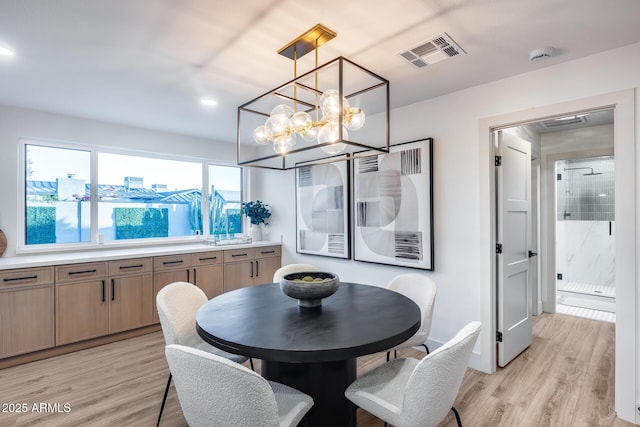 dining area with visible vents, recessed lighting, light wood-style flooring, and a notable chandelier