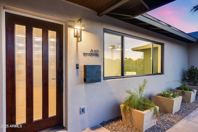 view of exterior entry featuring stucco siding