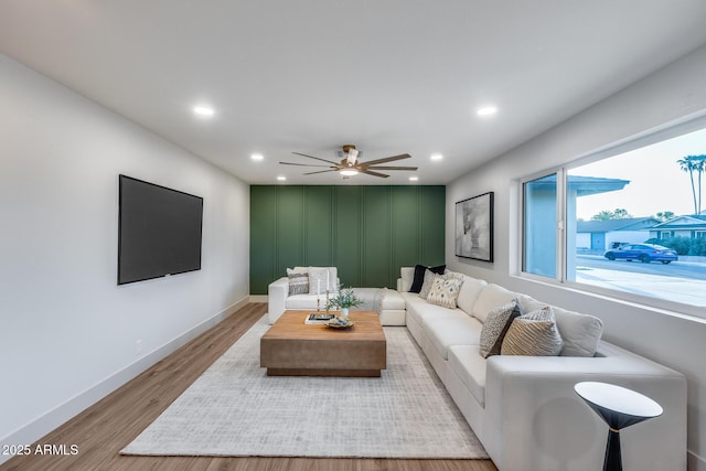 living area with a ceiling fan, baseboards, recessed lighting, and light wood-type flooring