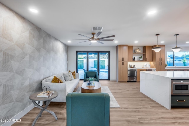 living area featuring plenty of natural light, ceiling fan, recessed lighting, and visible vents
