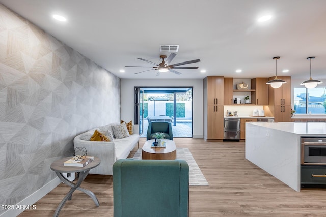 living room featuring plenty of natural light, a ceiling fan, recessed lighting, and visible vents