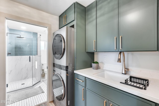 washroom with laundry area, a sink, and stacked washer and clothes dryer