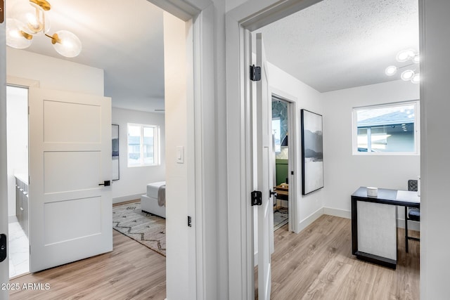 ensuite bathroom with baseboards, ensuite bath, wood finished floors, and a chandelier