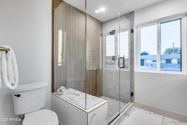 full bath featuring a shower stall and toilet