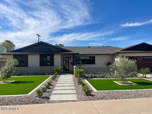 ranch-style house featuring stucco siding and a front yard