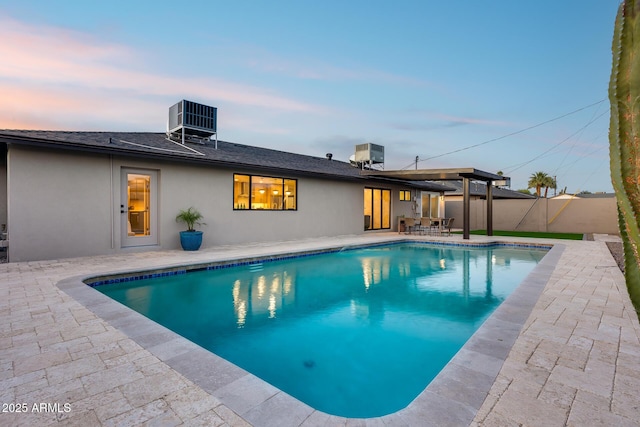 pool at dusk with a fenced in pool, central AC unit, a fenced backyard, and a patio area