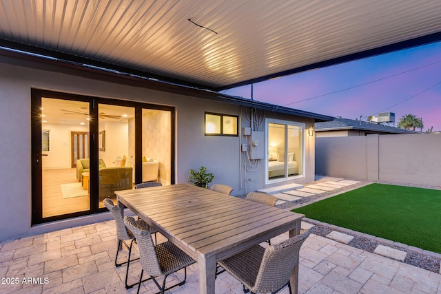 patio terrace at dusk with fence and outdoor dining space
