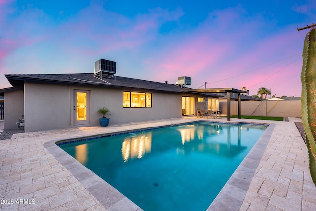 view of pool with cooling unit, a fenced backyard, a patio area, and a fenced in pool