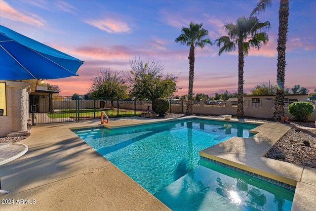 pool at dusk with a patio