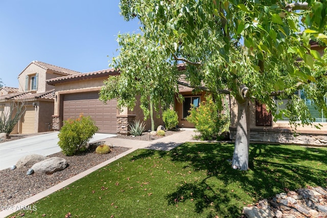 view of front facade with a front yard, stucco siding, concrete driveway, a garage, and a tile roof