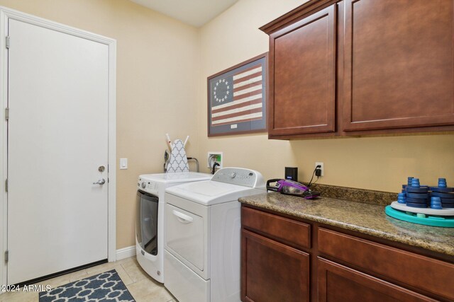 laundry area with light tile patterned floors, cabinets, and washer and dryer