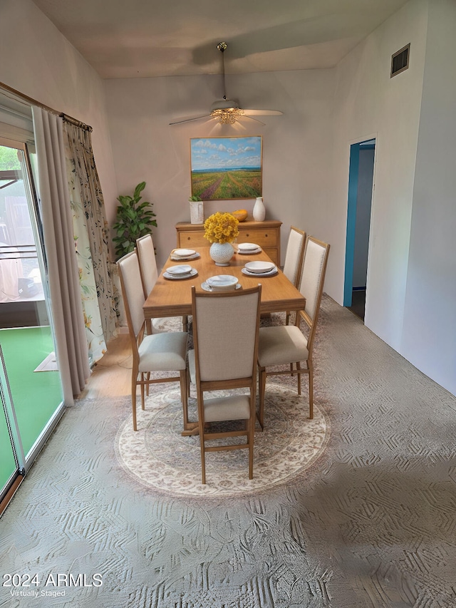 dining room with ceiling fan and light colored carpet