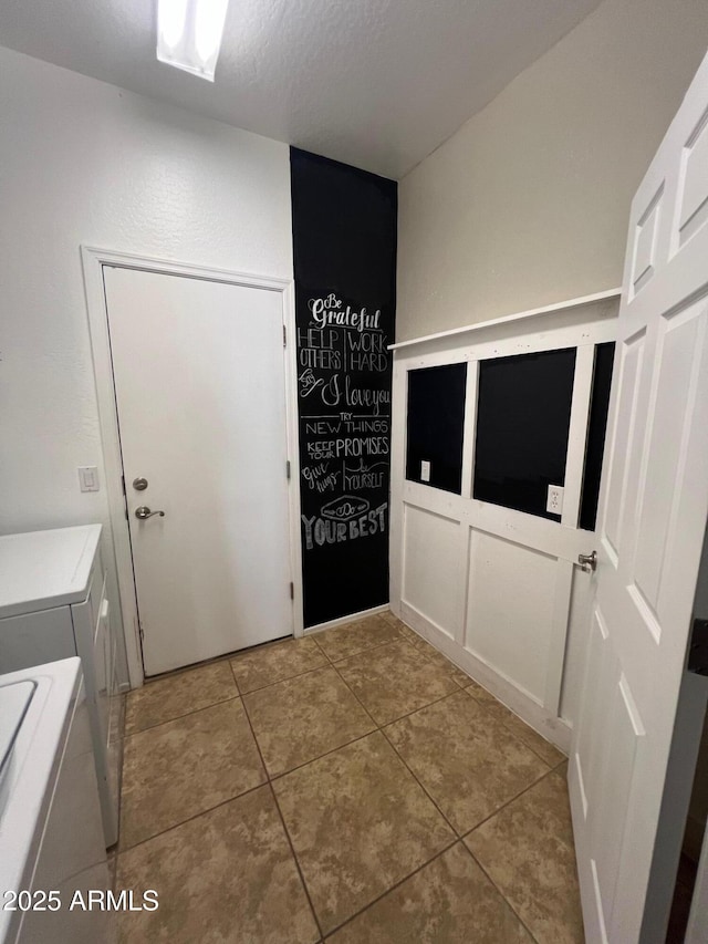 washroom with light tile patterned flooring, independent washer and dryer, and a textured ceiling