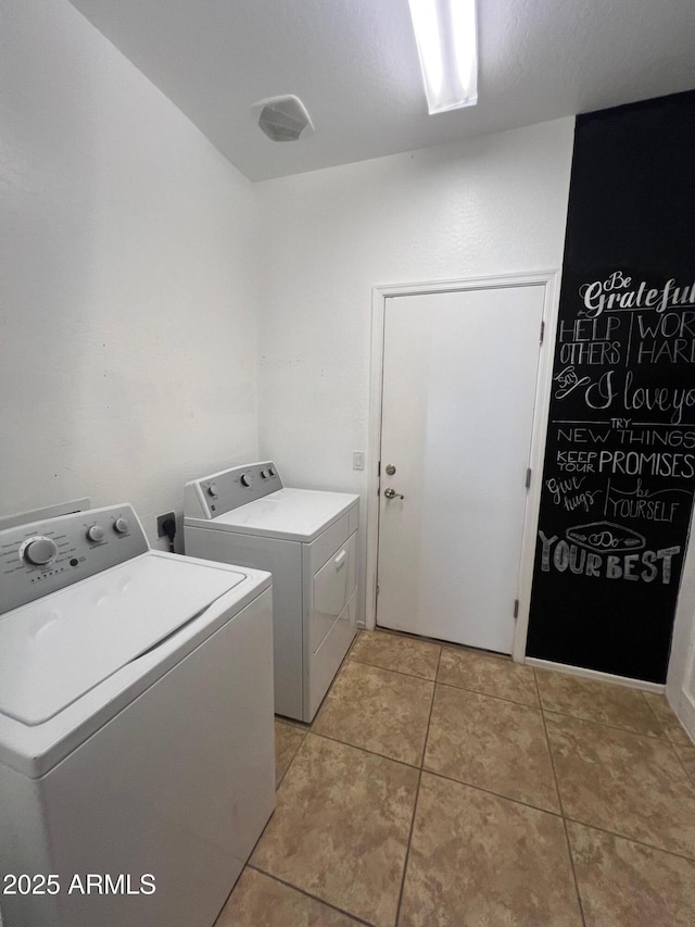 clothes washing area with light tile patterned floors and washing machine and dryer