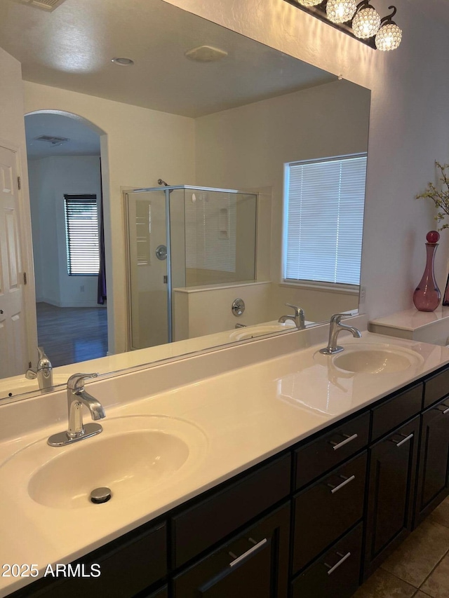 bathroom featuring a shower with door, vanity, and tile patterned flooring
