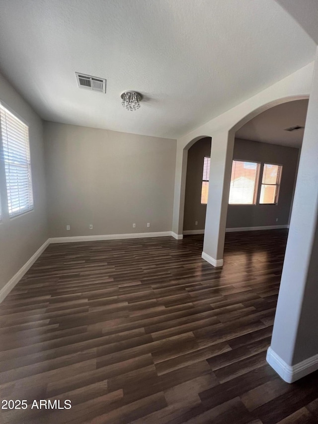 empty room featuring dark wood-type flooring and a textured ceiling