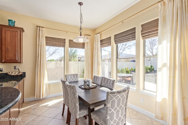 dining area with light tile patterned floors, baseboards, and a healthy amount of sunlight