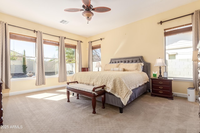 bedroom featuring baseboards, visible vents, ceiling fan, and light colored carpet