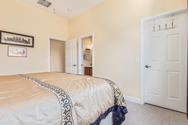 bedroom featuring carpet floors, visible vents, ensuite bath, and baseboards