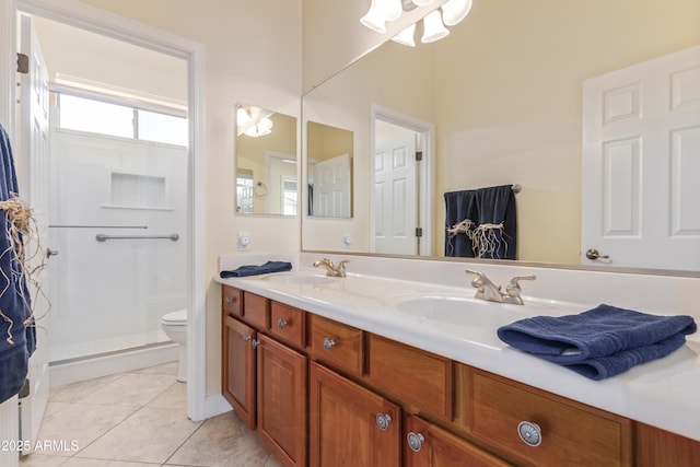 full bathroom featuring toilet, double vanity, a sink, and tile patterned floors