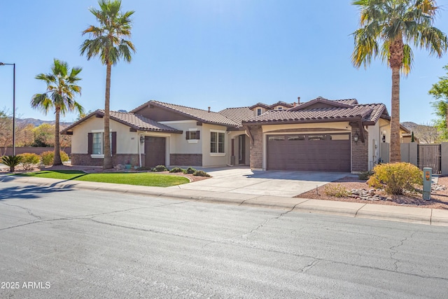 mediterranean / spanish house featuring concrete driveway, a tile roof, an attached garage, and stucco siding