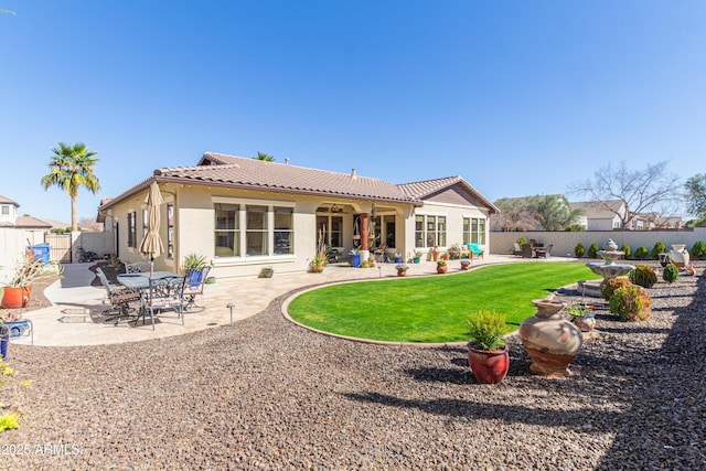 back of property featuring stucco siding, a tile roof, fence, and a patio