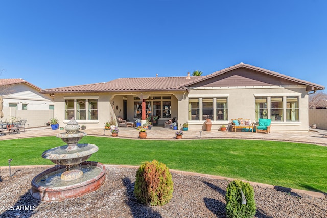 back of property featuring stucco siding, a tile roof, fence, and a patio