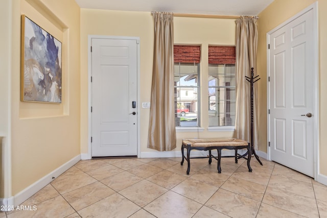 foyer featuring light tile patterned floors and baseboards