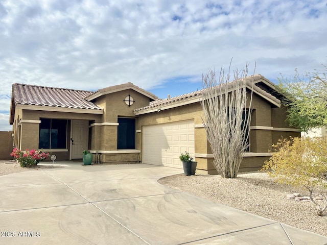 view of front of property with a garage, driveway, a tile roof, and stucco siding